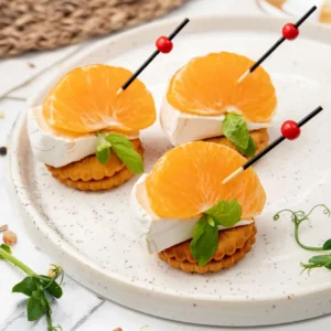 Canapes mit Camembertkäse und Obst auf einem Cracker